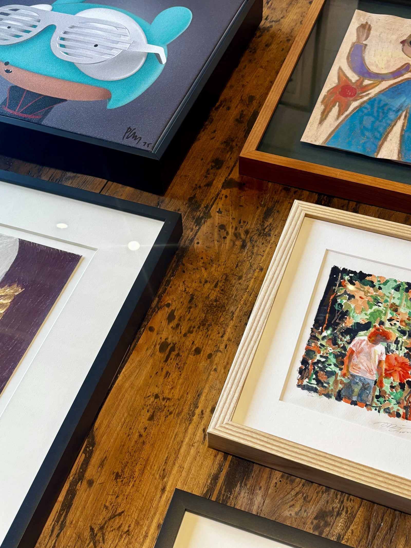 Group photo of custom-framed artworks by Edgar Plans, Isabella Cancino, Park Yongjae, Felix Treadwell, and Willem Hoeffnagel at Frames & Stretchers Miami, showcasing museum-quality mixed media framing.